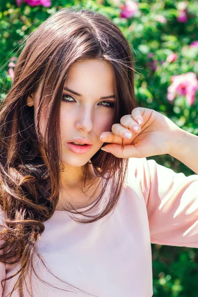 Utomhus mode foto av vackra unga glada leende kvinna omgiven av blommor. Våren blossom — Stockfoto