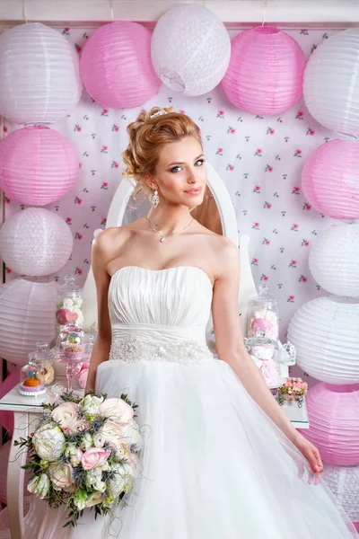 Krásná nevěsta s módní svatební účes a svatební šaty pózuje ve studiu — Stock fotografie