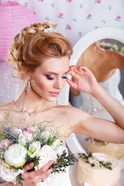 Beautiful bride with fashion wedding hairstyle and bouquet. Closeup portrait of young gorgeous bride. Wedding. Studio shot