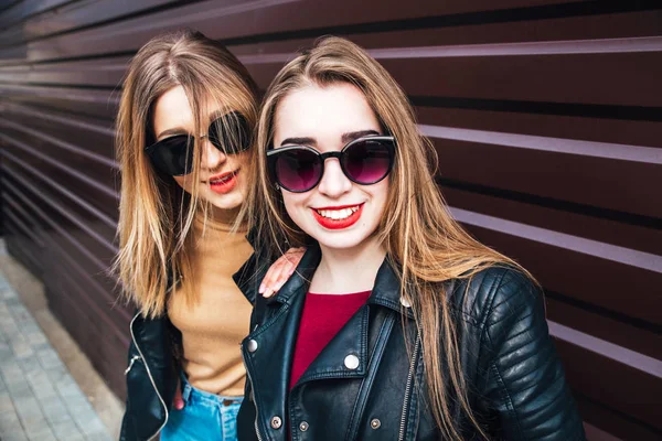 Dwie kobiety w City.Outdoor portret dwóch najlepszych przyjaciół dziewcząt hipster sobie stylowa Kurtka skórzana i okulary przeciwsłoneczne, wariuje i świetnie bawimy razem rozmawia — Zdjęcie stockowe