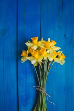 Sarı nergis buket mavi ahşap arka plan, Paskalya kartı üzerinde