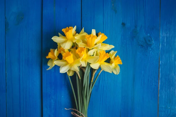 Μπουκέτο με κίτρινα daffodils σε μπλε φόντο ξύλινη, Πασχαλινή κάρτα — Φωτογραφία Αρχείου