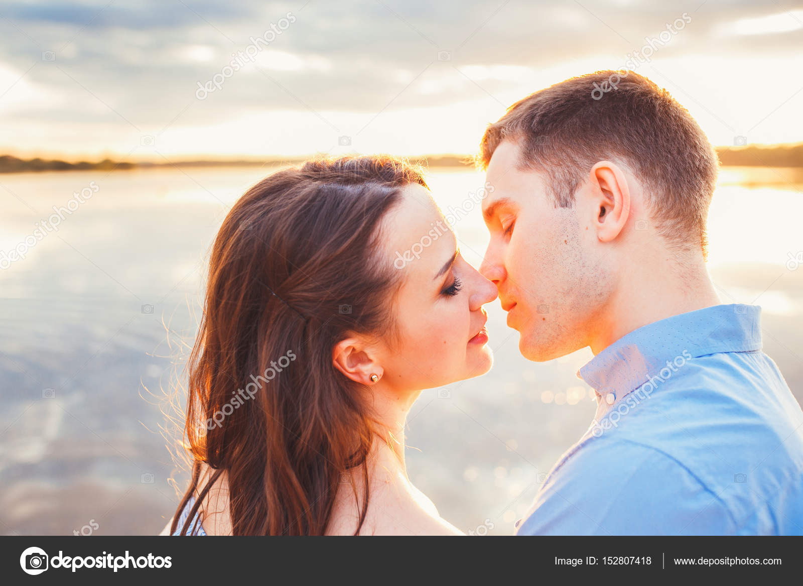 Young Beautiful Couple In Love Staying And Kissing On The Beach On