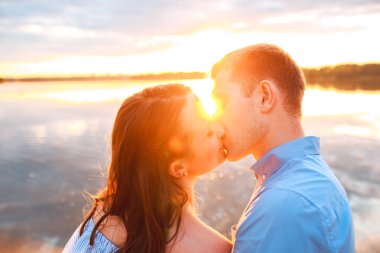 genç güzel bir çift kalıyor ve sahilde sunset bulvarında öpüşme seviyorum. yumuşak güneşli renkleri.