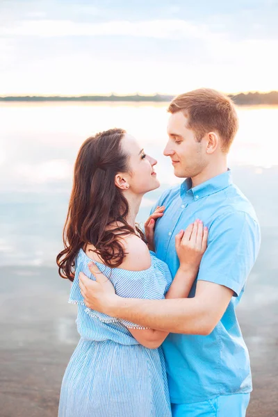 Jong koppel in liefde omhelzen elkaar op het meer buiten in de zomerdag, harmonie concept — Stockfoto