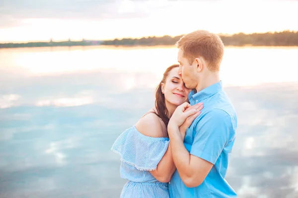 Jong koppel in liefde omhelzen elkaar op het meer buiten in de zomerdag, harmonie concept — Stockfoto