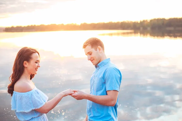 Frieri på sunset. ung man lägger fram ett förslag för förlovningen till sin flickvän — Stockfoto