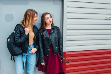 İki çekici genç kız arkadaş bir arada durup kameraya poz veriyorlar.