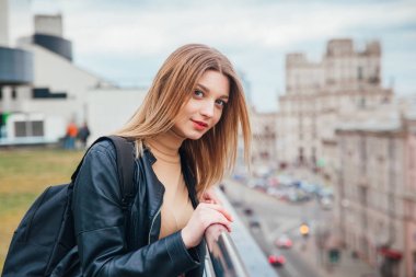 Çatı neşeli güzel moda kız portresi. Güzel şehir manzaralı