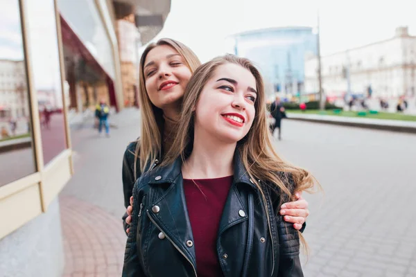 Två vänner möte i gatan av staden och kramas. vänskap, lycka koncept. Par kvinna — Stockfoto