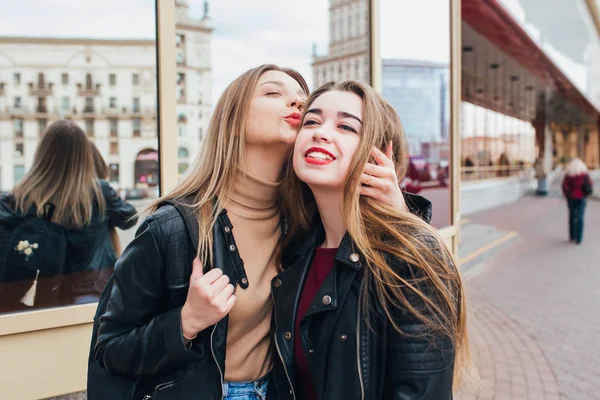 Dos amigos se reúnen en la calle de la ciudad y se abrazan. concepto de amistad, felicidad. Pareja de mujer —  Fotos de Stock