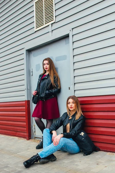 Twee aantrekkelijke jonge meisje vrienden samen staan en die zich voordeed op de camera. Mooie mode vrouwen poseren. Trendy lifestyle stedelijke portret op de achtergrond van de stad. — Stockfoto