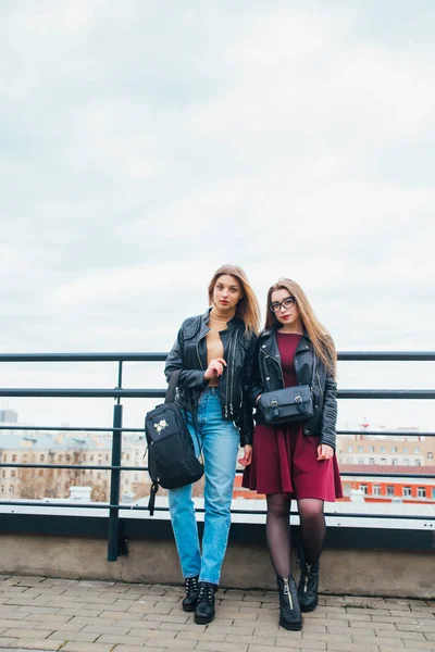 Δυο γυναίκες μαζί σε αστικό τοπίο. Δύο χαρούμενη όμορφα μοντέρνα κορίτσια στη στέγη. Όμορφη θέα στην πόλη — Φωτογραφία Αρχείου