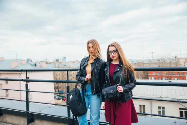 Dvě ženy spolu v panoráma. Dvě radostné krásné módní dívky na střeše. Krásným výhledem na město — Stock fotografie