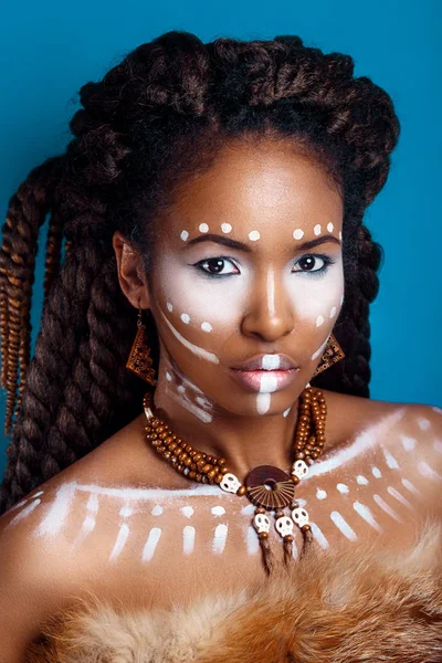 Mujer de estilo africano. Mujer joven atractiva en joyería étnica. primer plano retrato de una mujer con una cara pintada. Maquillaje creativo y estilo brillante . — Foto de Stock