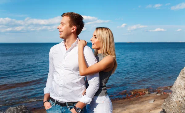 Lyckliga paret på havet bakgrund. Glada unga par skratta och kramas på stranden — Stockfoto