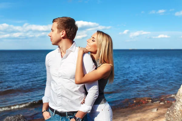 Lyckliga paret på havet bakgrund. Glada unga par skratta och kramas på stranden — Stockfoto
