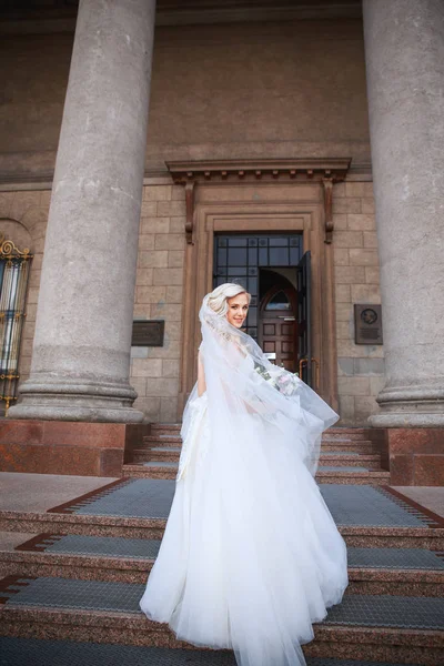 Hermosa novia feliz al aire libre. Hermosa novia con ramo de flores al aire libre. Hermosa novia posando en su día de boda — Foto de Stock