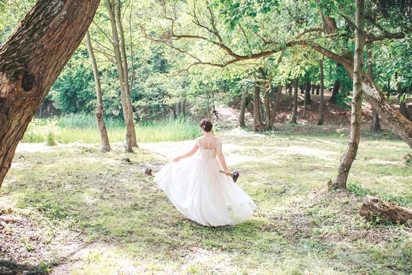 公園を歩いていたら白のヴィンテージのドレスの美しい花嫁. — ストック写真