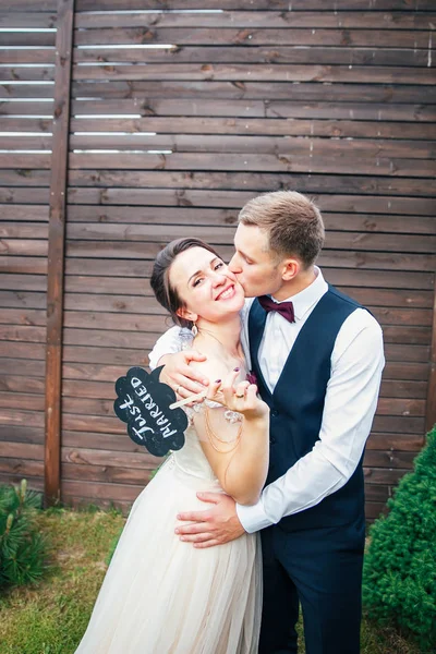 Novia y novio con un cartel que acaba de casarse. detalles dulces de la boda en el día de la boda — Foto de Stock