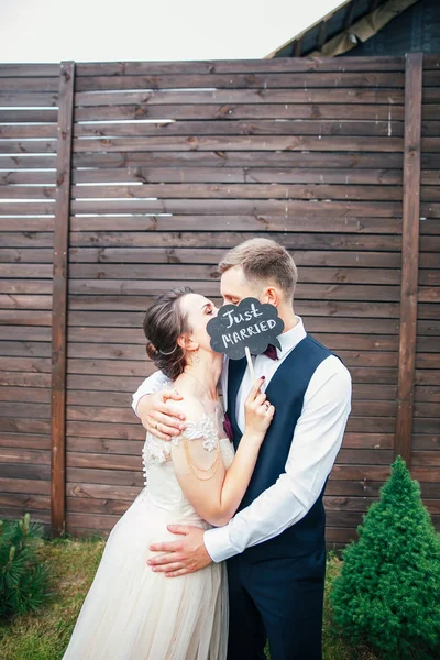Bruden och brudgummen med en skylt som bara gift. söta bröllop detaljer på bröllopsdagen — Stockfoto