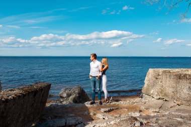 Genç bir çift sahilde yürüyor.