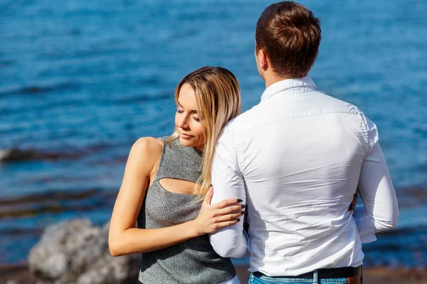 Hermosa joven con su novio en la playa — Foto de Stock