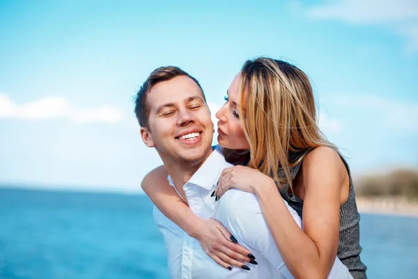 Par i kärlek ha roligt skrattar och ler mot stranden — Stockfoto