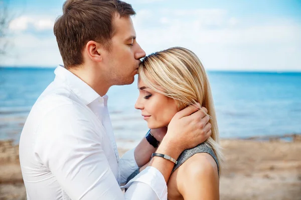 Romántica pareja joven de pie cabeza a cabeza en la playa — Foto de Stock