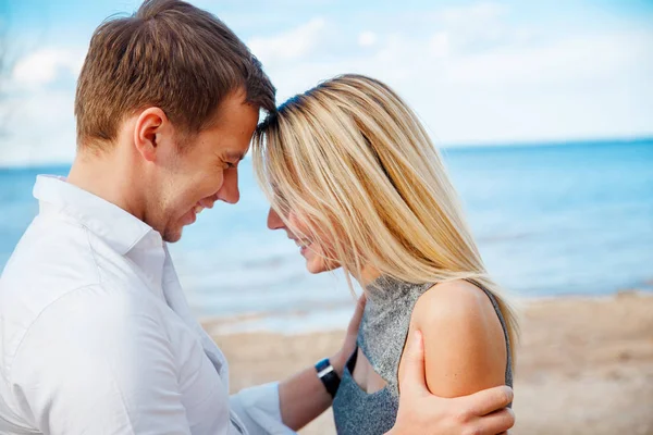 Romantische jong koppel staande kop aan kop op strand — Stockfoto