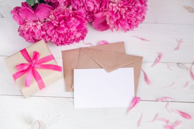 Pembe peonies çiçek ve ahşap arka plan üzerinde boş etiket. Üstten Görünüm kopya alanı ile. Anneler günü ya da kadın gün