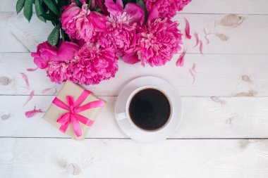 Bir fincan kahve, pembe peonies desen ve hediye kutusu ahşap arka plan üzerinde