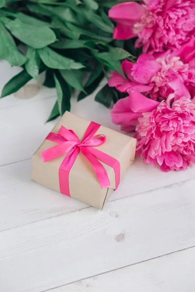 Linda flor de peônia rosa fresca com caixa de presente em fundo de madeira. Verão das peônias.Dia das mães ou dia das mulheres — Fotografia de Stock