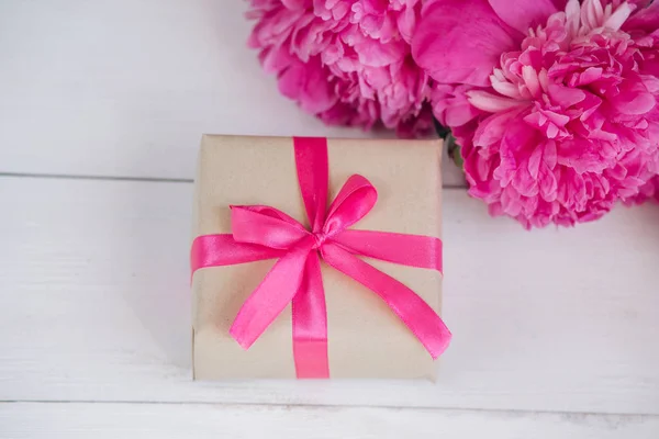Linda flor de peônia rosa fresca com caixa de presente em fundo de madeira. Verão das peônias.Dia das mães ou dia das mulheres — Fotografia de Stock