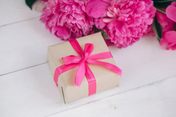 Mooie frisse roze pioen bloem met de doos van de gift op houten achtergrond. Pioenrozen zomer. Moeders of Womens dag — Stockfoto