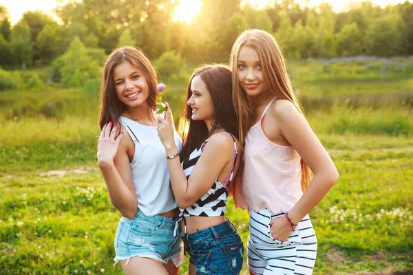 açık havada birbirlerine sarılma ve sunset bulvarında gülüyor üç kadın.