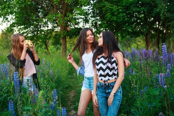 Tre ragazze hipster bionde e brune scattare autoritratto sulla macchina fotografica polaroid e sorridente all'aperto. Ragazze che si divertono insieme nel parco . — Foto Stock