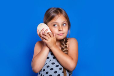 Mutlu bir çocuk için deniz kabuğu dinle. Yaz tatil ve seyahat kavramı