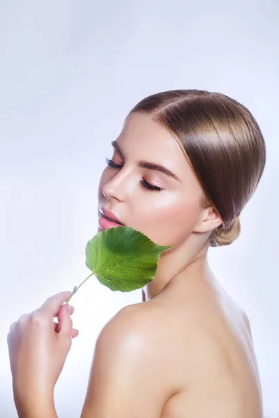Cosmética orgánica. Hermoso retrato facial de mujer con hoja verde, concepto para el cuidado de la piel o cosméticos orgánicos —  Fotos de Stock