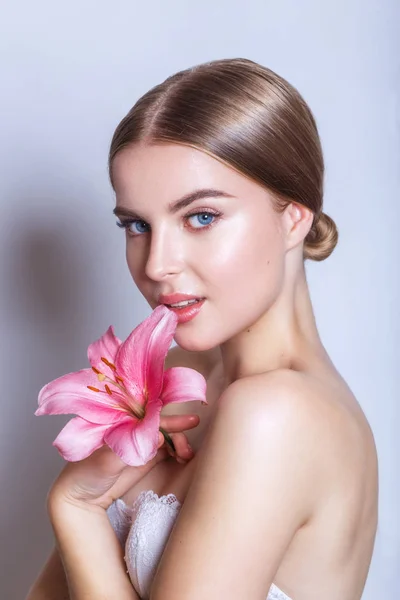 Rosto de beleza de mulher jovem com flor. Conceito de tratamento de beleza. Retrato sobre fundo branco — Fotografia de Stock