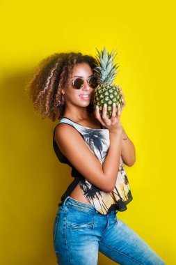 Moda portre afro Amerikan kız güneş gözlüğü ve ananas sarı arka plan üzerinde