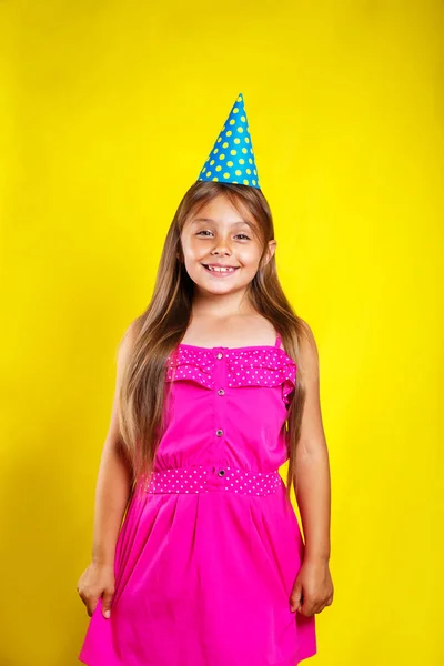 Studio πορτρέτο του ένα μικρό κορίτσι που φοράει ένα καπέλο πάρτι για τα γενέθλιά της. Χαριτωμένο κορίτσι Διασκεδάζοντας. — Φωτογραφία Αρχείου