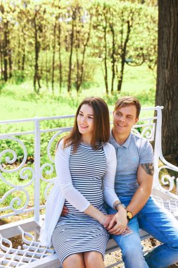 Yakışıklı ve güzel hamile eşi sarılma ve park dururken gülümseyen