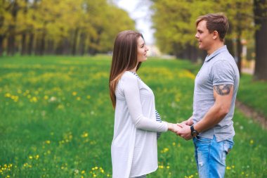 Yürüyüş ve parkta elele kocası ile hamile kadın