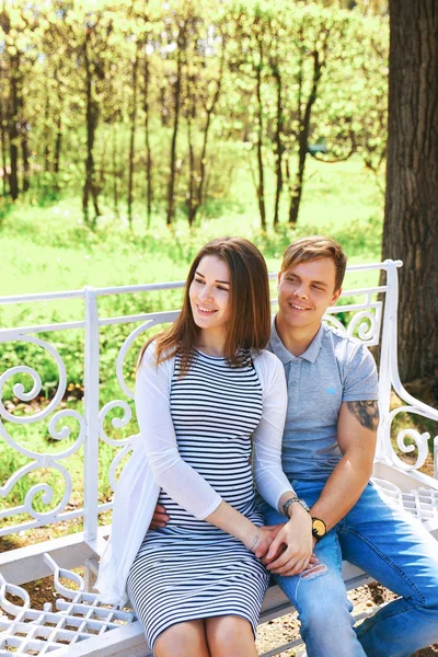 Yakışıklı ve güzel hamile eşi sarılma ve park dururken gülümseyen