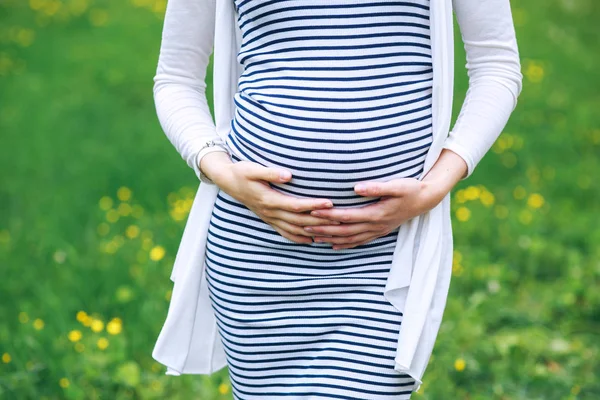 Gravid kvinna poserar i parken — Stockfoto