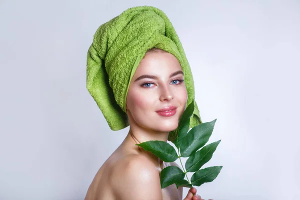 Νεαρή όμορφη γυναίκα με μια πράσινη πετσέτα στο κεφάλι της — Φωτογραφία Αρχείου