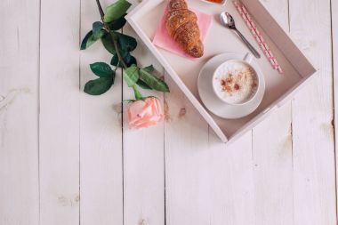 Kahve kupa ile kruvasan, gül, reçel ve rahat notlar Günaydın üzerinde beyaz rustik tablo yukarıda ve lezzetli breakfast, vintage tonlu
