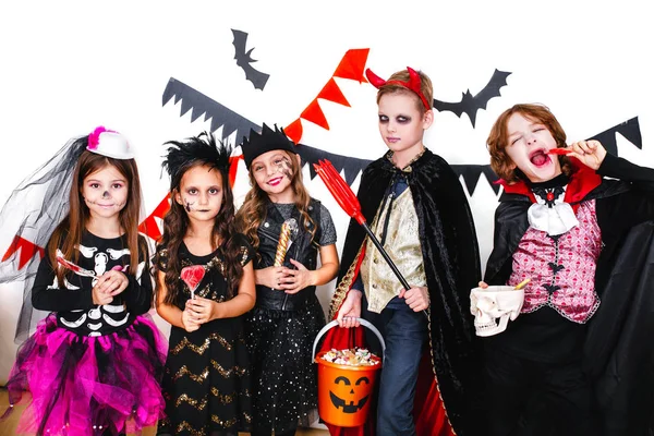 Kinderen in halloween kostuums vertonen grappige gezichten — Stockfoto