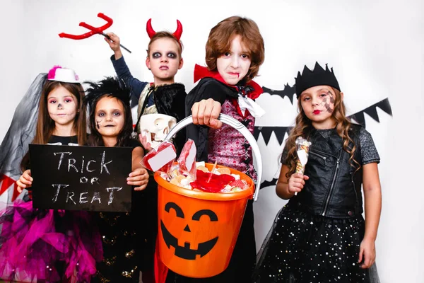 Barn i halloween kostymer visar roliga ansikten — Stockfoto